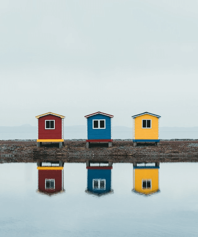 In this example, we upload a PNG of fishing houses and posterize it using two custom colors. We paint the sky and water reflections of the houses in pink color and fill the darker regions with midnight-blue color. (Source: Pexels.)